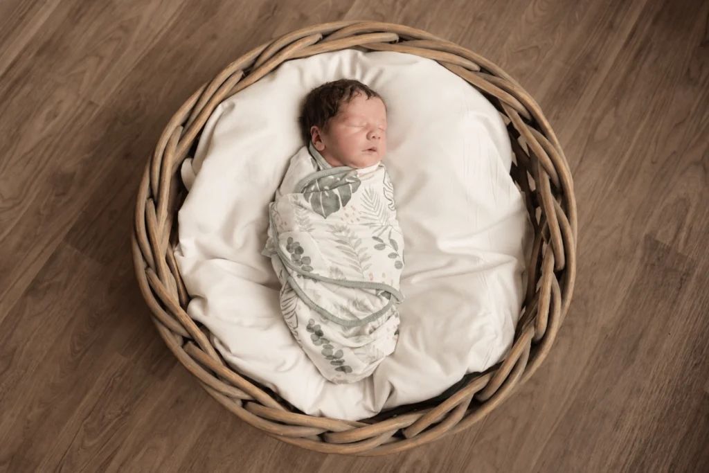 Newborn baby sleeping in a wicker basket