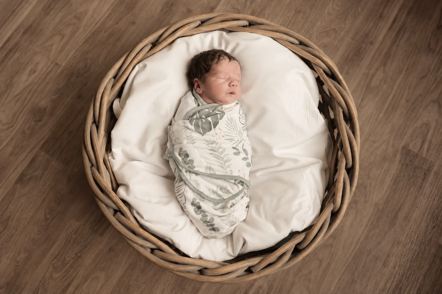 Newborn baby sleeping in a wicker basket