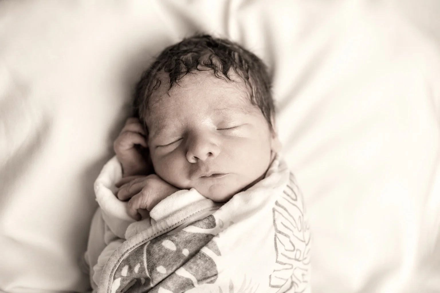 Sleeping newborn in a floral swaddle